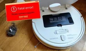 Robot aspirador Xiaomi sin wifi muestra un error fatal. Un montón de polvo y pelusa yace a su lado.