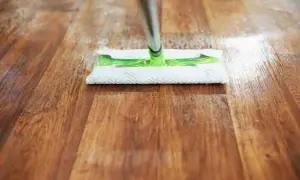 Mopa limpiando un suelo de madera, ideal para saber como quitar rayas en el suelo de vinilo y mantenerlo impecable.