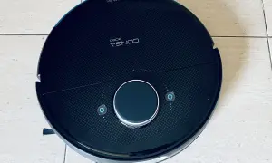Robot aspirador Conga 8090, negro, con botones de inicio y retorno. Parece tener problemas.