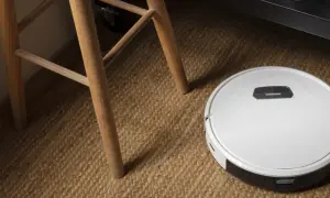 Robot aspirador Cecotec en alfombra de yute, cerca de las patas de una silla de madera. ¿Posibles averías?