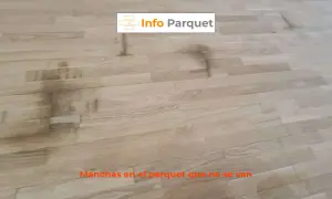 Manchas oscuras y persistentes en el parquet de madera clara, un problema común que requiere solución.
