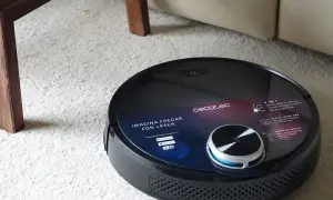 Robot aspirador Conga negro sobre alfombra blanca. Pregúntate cuanto tarda en cargar la Conga para tenerla lista para limpiar.