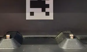 Dos contactos de carga de un Roomba, con un marcador QR encima. Posible error de carga 1.