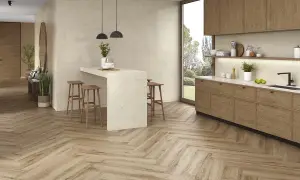 Cocina moderna con suelo de madera en espiga, el mejor suelo para cocina, isla con taburetes y muebles de madera.
