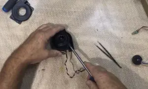 Reparando el ventilador de un Roomba con error 26. Se usa un destornillador para desmontar la pieza.