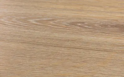 Textura de suelo laminado de madera clara, con vetas finas y paralelas. Podría ser un ejemplo de problemas de suelo laminado artens.