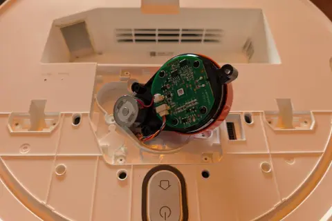 Componentes internos de un robot aspirador Xiaomi, mostrando el motor y la placa base, parte del proceso para desmontar rueda xiaomi vacuum.
