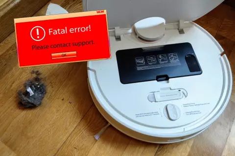 Robot aspirador Xiaomi sin wifi muestra un error fatal. Un montón de polvo y pelusa yace a su lado.
