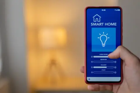 Mano usa el **apaga luz app** en su teléfono para controlar las luces de la casa.