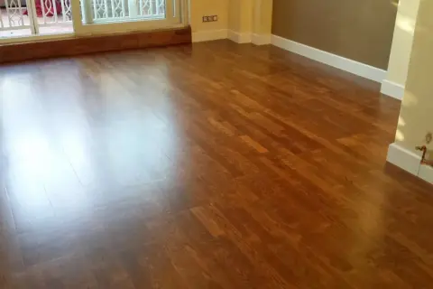 Parquet de madera con acabado brillante, listo para cambiar color y renovar el espacio.