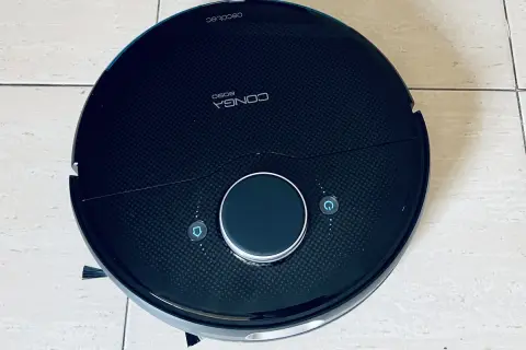 Robot aspirador Conga 8090, negro, con botones de inicio y retorno. Parece tener problemas.