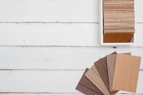 Muestras de parquet laminado de distintos tonos y grosores, dispuestas en abanico y en un expositor.