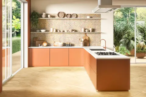 Tarima para cocinas y baños con diseño geométrico en tonos tierra. Muebles naranjas y encimera blanca.