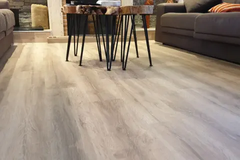 Suelo de tarima flotante de madera clara, con un diseño moderno y natural. Las medidas de la tarima flotante son perfectas para este salón.