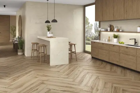 Cocina moderna con suelo de madera en espiga, el mejor suelo para cocina, isla con taburetes y muebles de madera.