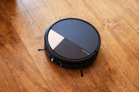 Robot aspirador Roomba con tecnología dirt detect, listo para limpiar el suelo de madera.