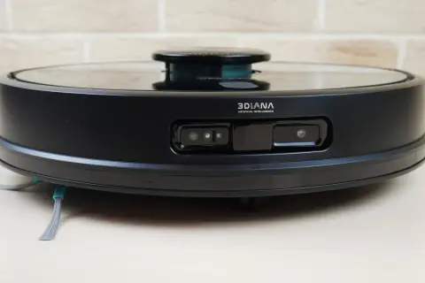 Aspiradora robot negra con sensores frontales y cepillos laterales. El modelo conga 7090 lista para limpiar tu hogar.