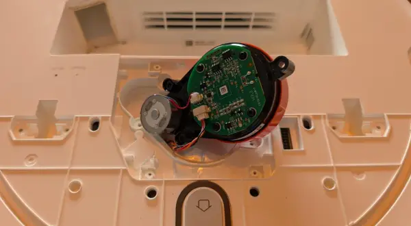 Componentes internos de un robot aspirador Xiaomi, mostrando el motor y la placa base, parte del proceso para desmontar rueda xiaomi vacuum.
