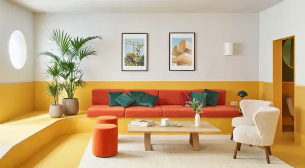 Salón moderno con sofá naranja, butacas blancas y **suelos de linóleo** amarillo vibrante. Plantas verdes y cuadros decoran el espacio.