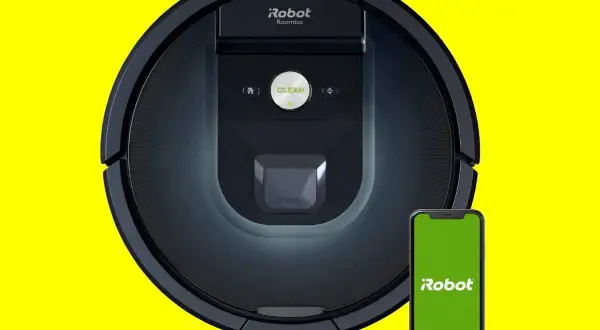 Robot aspirador Roomba 981 negro junto a un smartphone con pantalla verde.