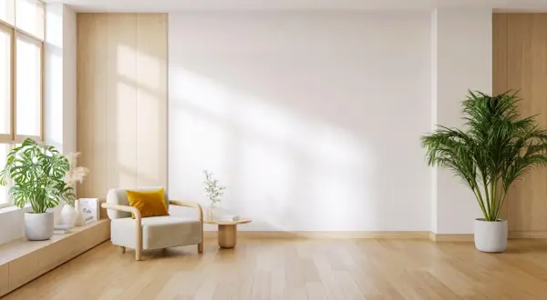Elegante salón con instalación de tarimas de madera clara, sillón acogedor y plantas verdes.