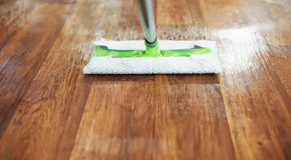 Mopa limpiando un suelo de madera, ideal para saber como quitar rayas en el suelo de vinilo y mantenerlo impecable.