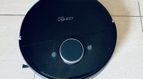 Robot aspirador Conga 8090, negro, con botones de inicio y retorno. Parece tener problemas.