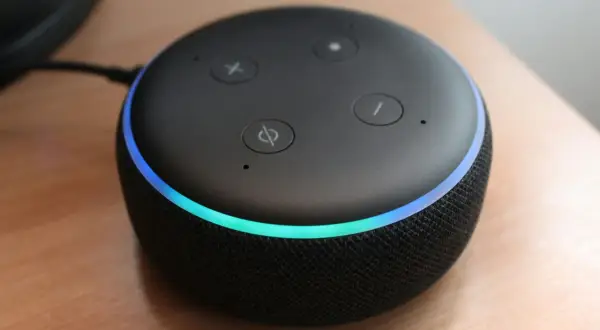 Altavoz inteligente con luz azul y verde, listo para encender Alexa y responder tus preguntas.