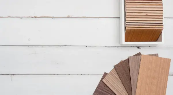 Muestras de parquet laminado de distintos tonos y grosores, dispuestas en abanico y en un expositor.