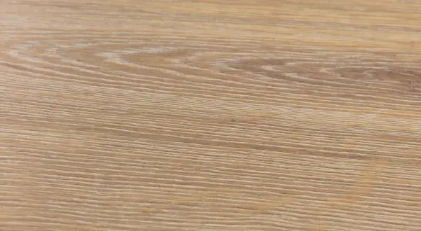 Textura de suelo laminado de madera clara, con vetas finas y paralelas. Podría ser un ejemplo de problemas de suelo laminado artens.