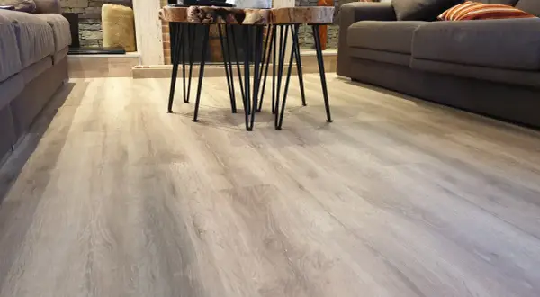 Suelo de tarima flotante de madera clara, con un diseño moderno y natural. Las medidas de la tarima flotante son perfectas para este salón.