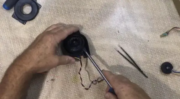 Reparando el ventilador de un Roomba con error 26. Se usa un destornillador para desmontar la pieza.