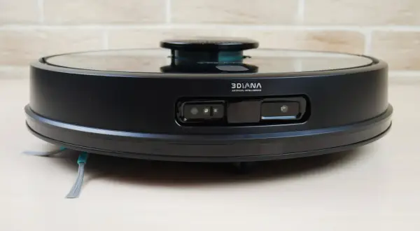 Aspiradora robot negra con sensores frontales y cepillos laterales. El modelo conga 7090 lista para limpiar tu hogar.
