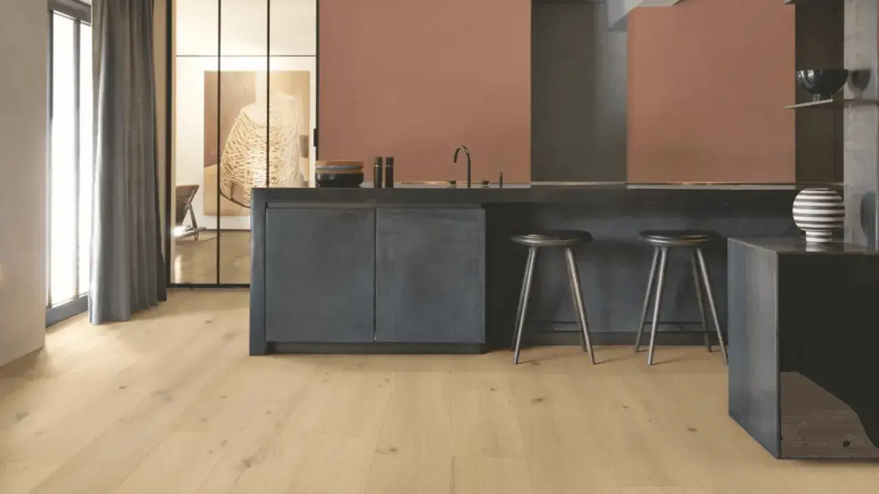 Cocina moderna con suelo vinílico adhesivo o click de madera clara, isla oscura y taburetes.
