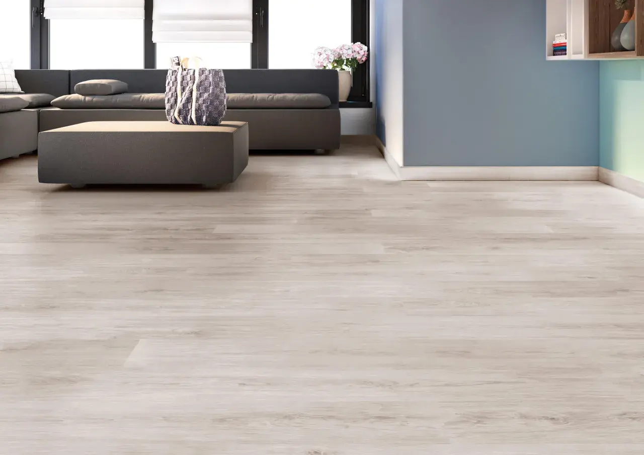 Suelos laminados colores actuales, con un sofá gris y una mesa de centro, en una sala de estar moderna.