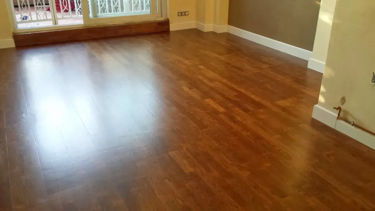 Parquet de madera con acabado brillante, listo para cambiar color y renovar el espacio.