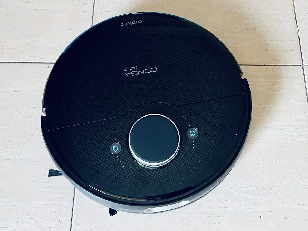 Robot aspirador Conga 8090, negro, con botones de inicio y retorno. Parece tener problemas.