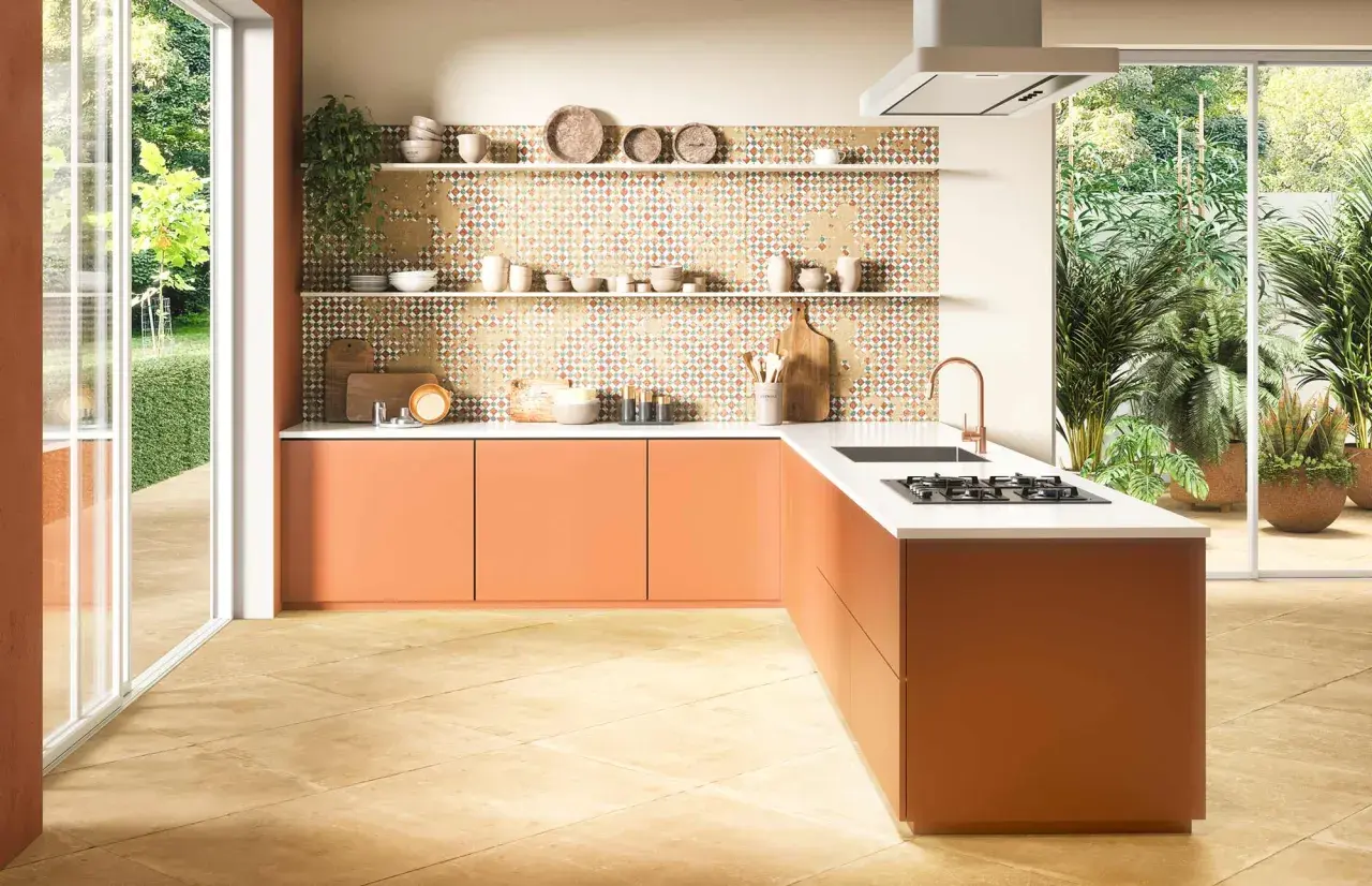 Tarima para cocinas y baños con diseño geométrico en tonos tierra. Muebles naranjas y encimera blanca.