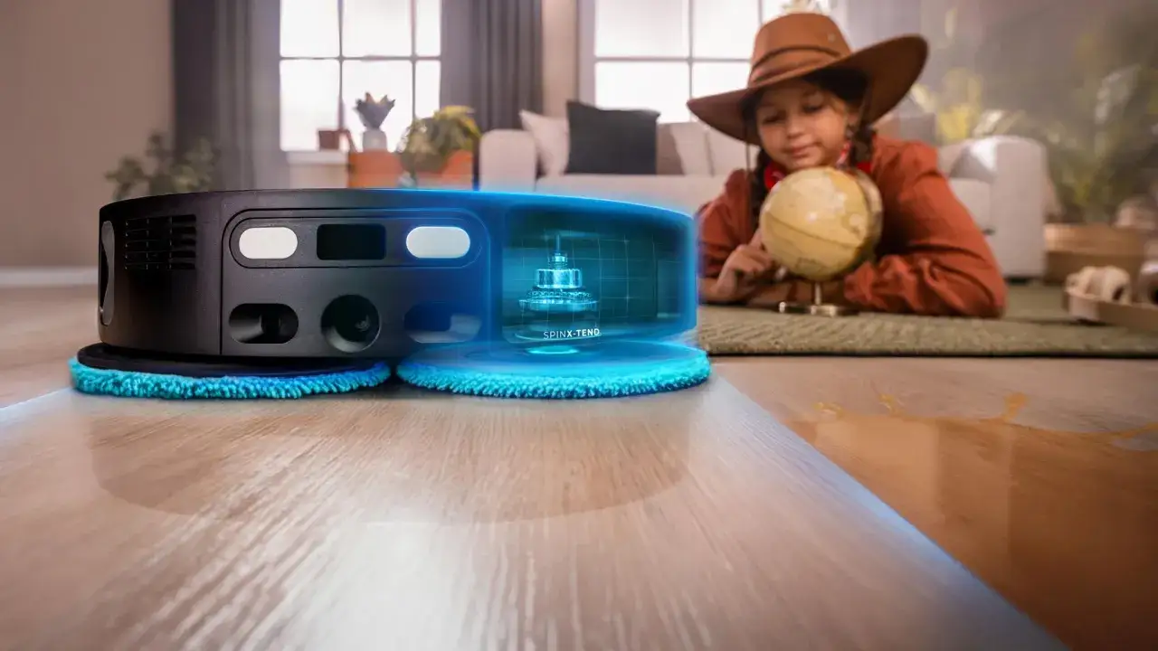 Aspiradora robot conga 2490 limpiando un derrame. Una niña con sombrero de exploradora mira un globo terráqueo.