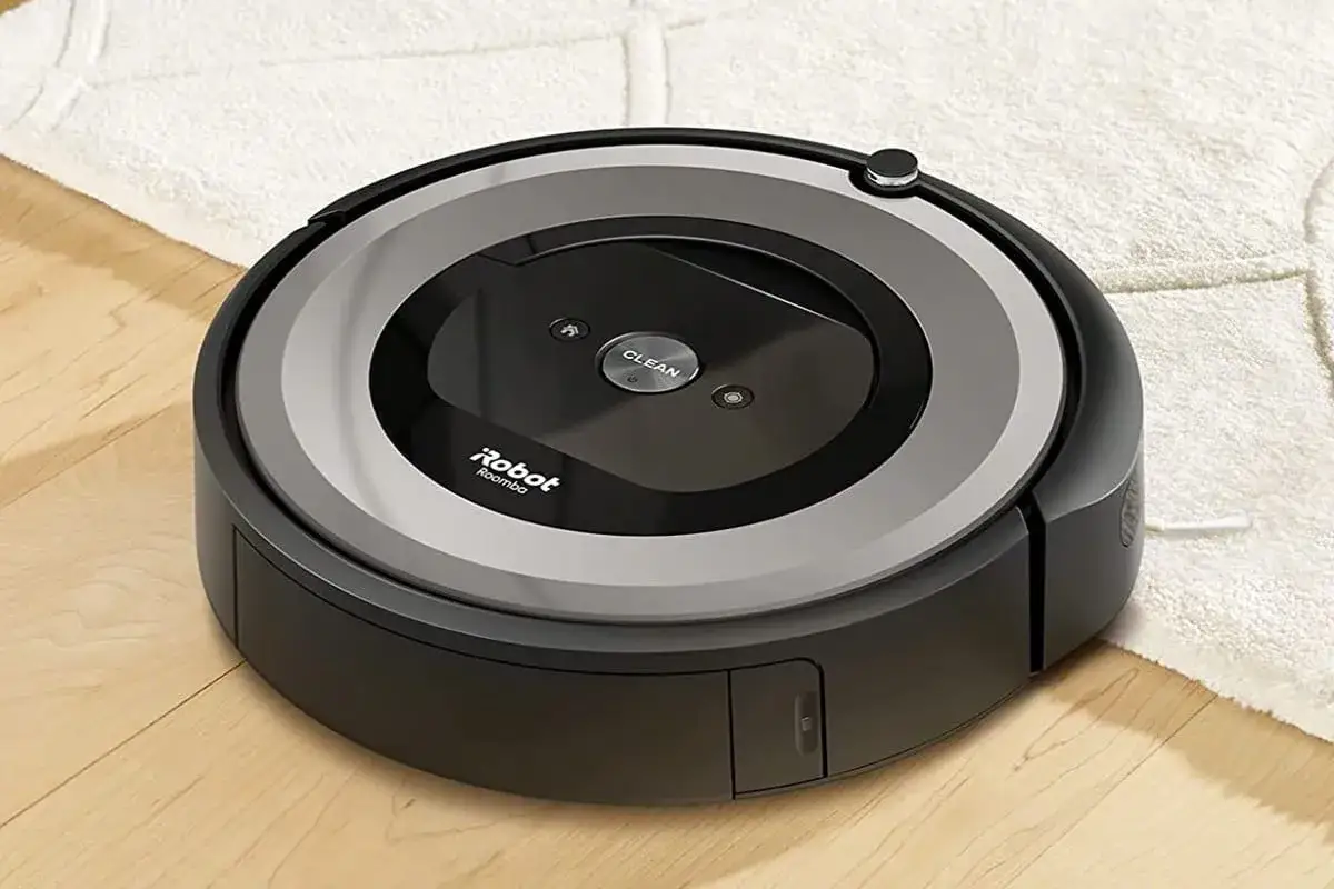 Robot aspirador Roomba en suelo de madera y alfombra. Opiniones positivas sobre su limpieza.