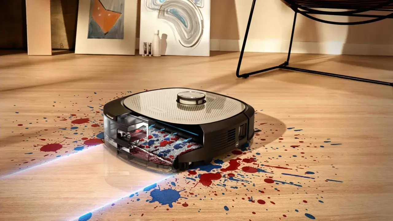 Robot aspirador limpiando manchas de pintura roja y azul. Para que la conga tenga que estar siempre enchufada, su bater&iacute;a se recarga autom&aacute;ticamente.