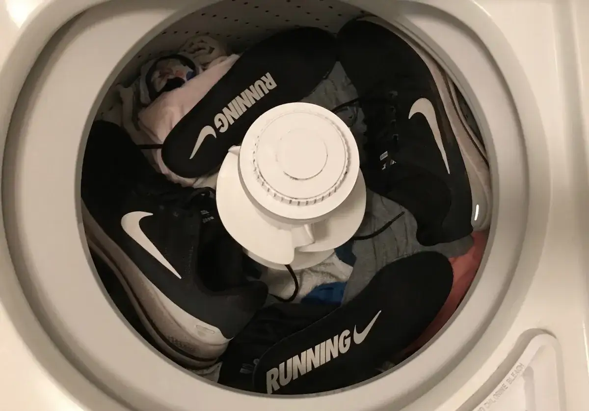 Zapatos deportivos Nike negros listos para lavar en lavadora. Las plantillas con la palabra 