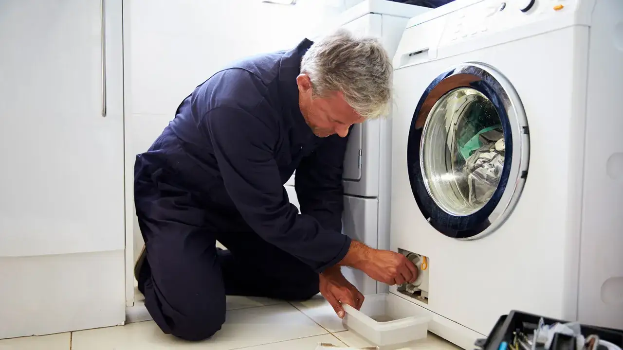 T&eacute;cnico revisa lavadora, asegurando la garant&iacute;a lavadora. Un profesional en acci&oacute;n, solucionando problemas.