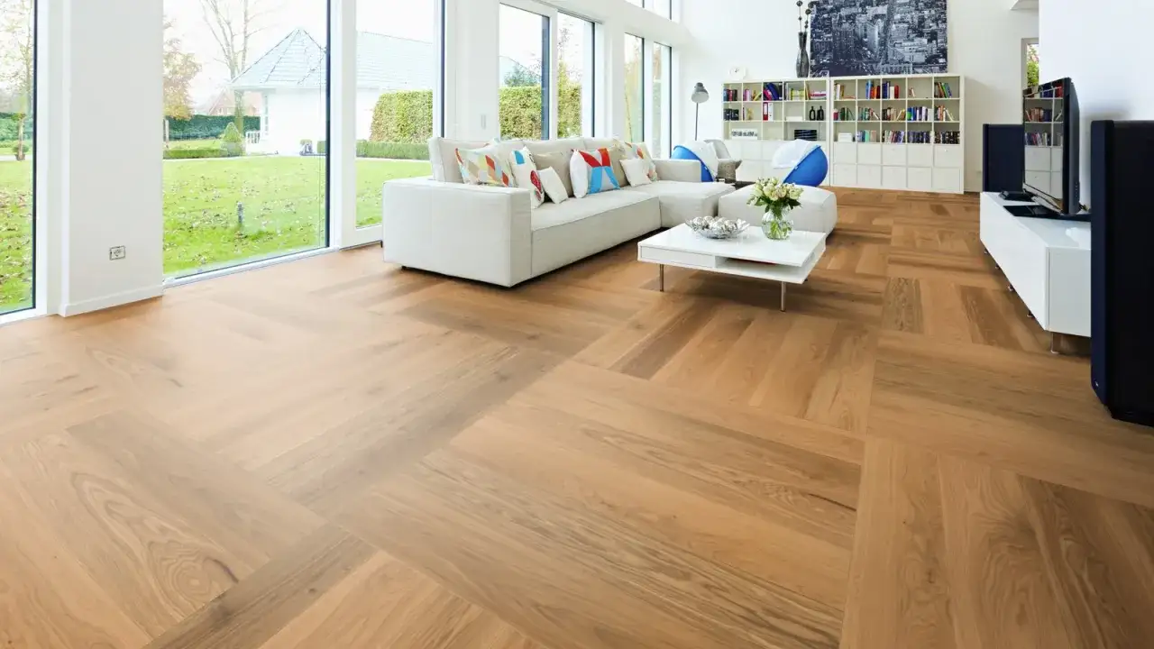 El suelo de madera de esta casa de campo, con su dise&ntilde;o en espiga, aporta calidez y estilo a la sala de estar.