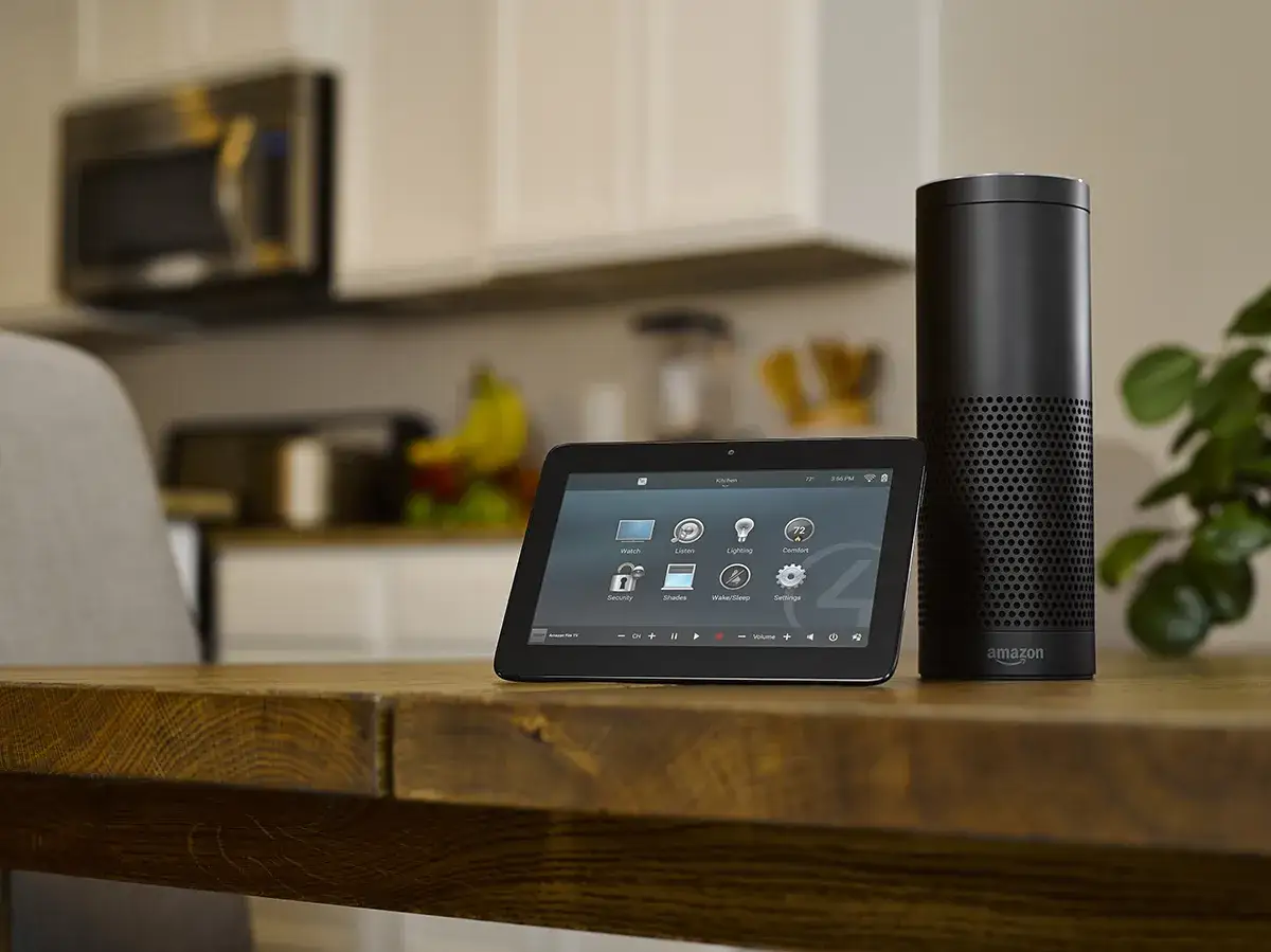 Tableta y altavoz inteligente en una cocina, listos para recibir tu comando de voz.