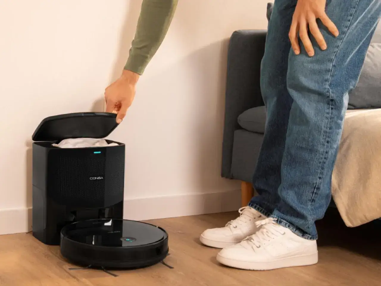 Persona abre la base de carga de su robot Conga. &iexcl;Limpieza f&aacute;cil sin wifi!