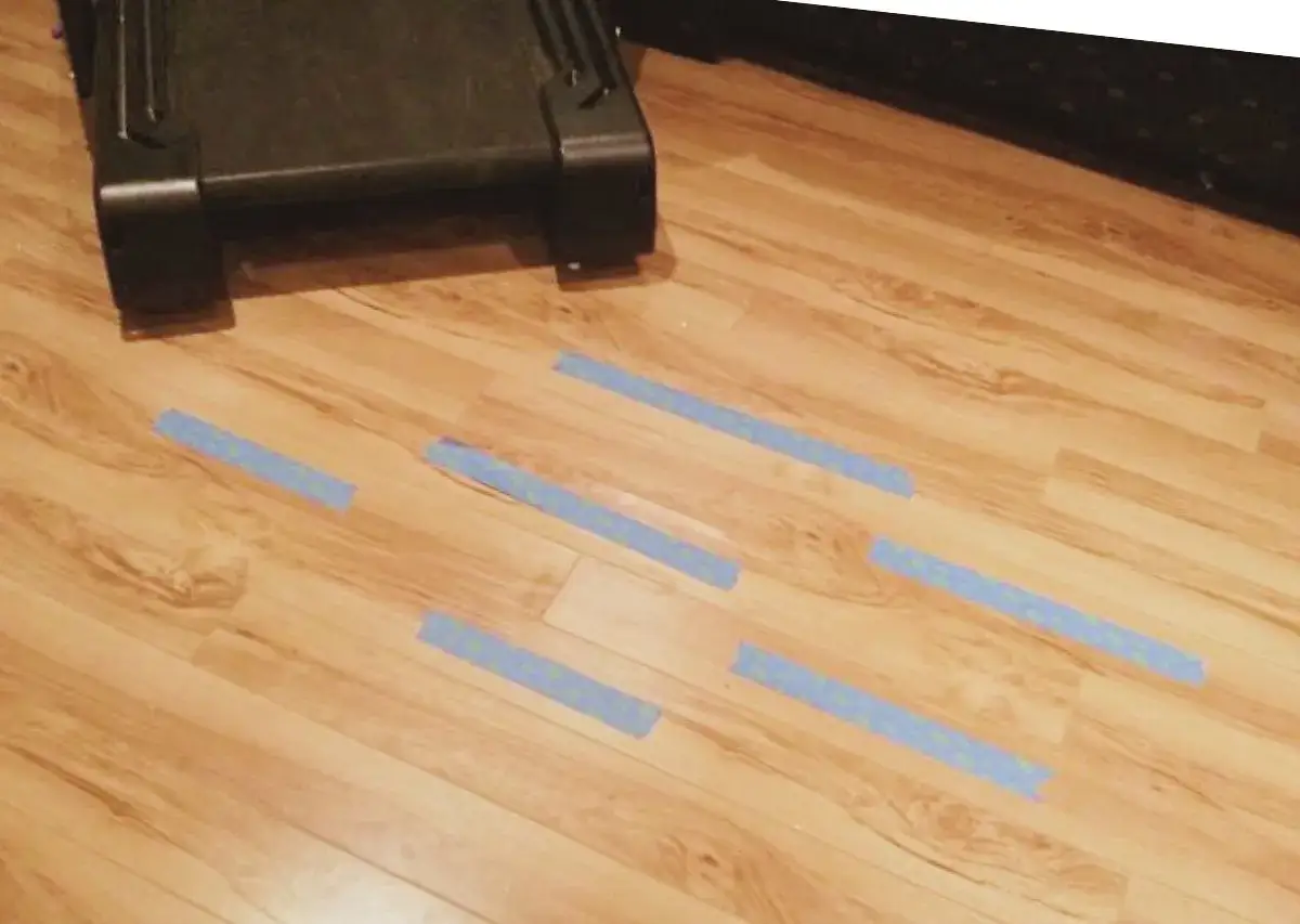 Se despegan los suelos de vinilo. Tiras de cinta azul marcan las &aacute;reas donde el suelo se est&aacute; levantando.
