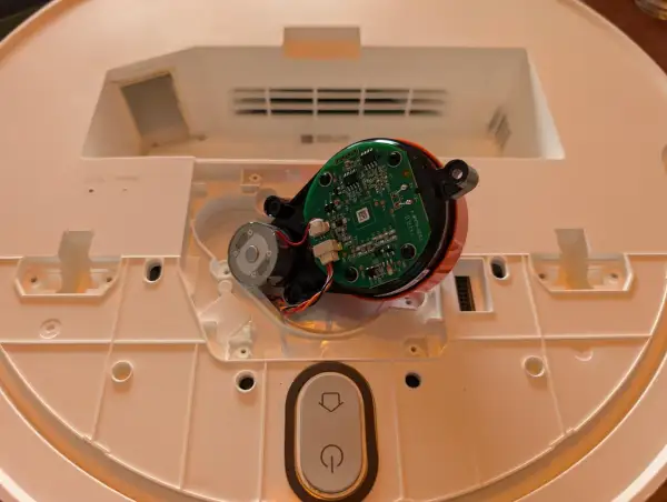 Componentes internos de un robot aspirador Xiaomi, mostrando el motor y la placa base, parte del proceso para desmontar rueda xiaomi vacuum.