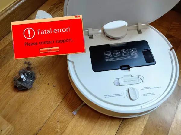 Robot aspirador Xiaomi sin wifi muestra un error fatal. Un montón de polvo y pelusa yace a su lado.
