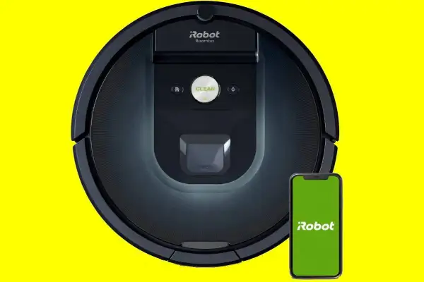 Robot aspirador Roomba 981 negro junto a un smartphone con pantalla verde.